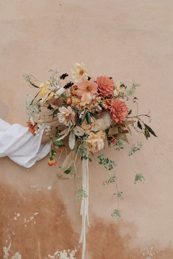 Hand Holding a Bouquet of Flowers